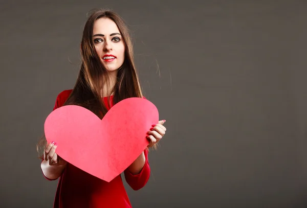 Donna in abito rosso tiene il segno del cuore — Foto Stock