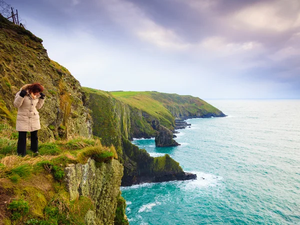 Ιρλανδική ακτή του Ατλαντικού. Γυναίκα τουρίστρια στέκεται στο βράχο γκρεμό — Φωτογραφία Αρχείου