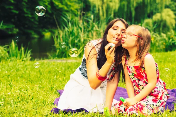 Mor och dotter blåser såpbubblor — Stockfoto