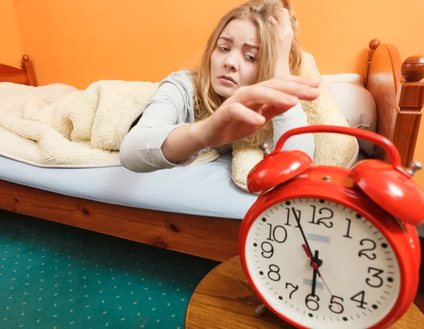 Woman waking up turning off alarm clock in morning — Stock Photo, Image