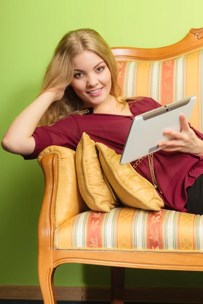 躺在沙发上用 pc 平板电脑的时尚女人. — 图库照片