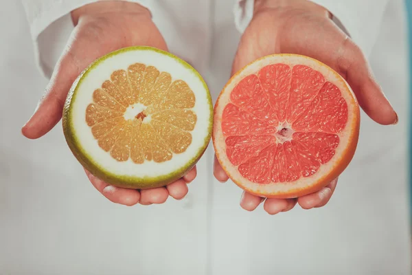 Person mänskliga med grapefrukt i händer. — Stockfoto
