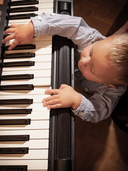 Boy child kid playing on digital keyboard piano synthesizer — Stock Photo, Image