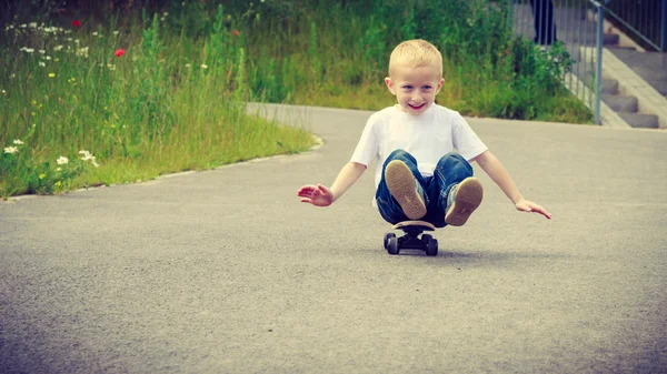 Bambino bambino seduto su skateboard divertirsi all'aperto — Foto Stock