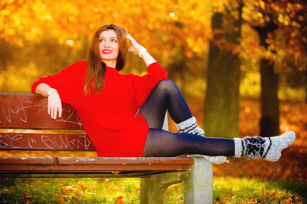 Mädchen entspannt sich auf Bank im herbstlichen Park. — Stockfoto