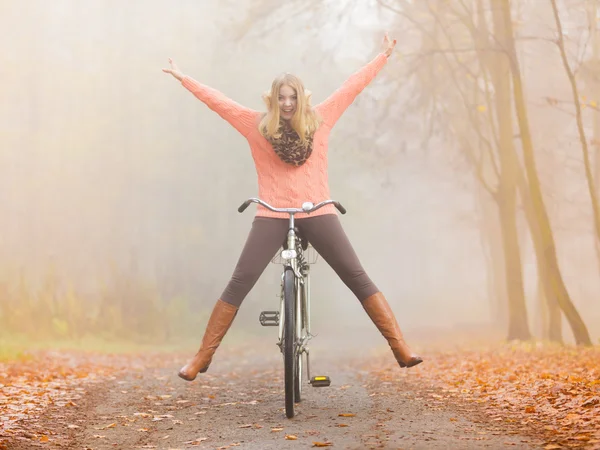 Mujer activa que se divierte montando bicicleta en el parque de otoño —  Fotos de Stock