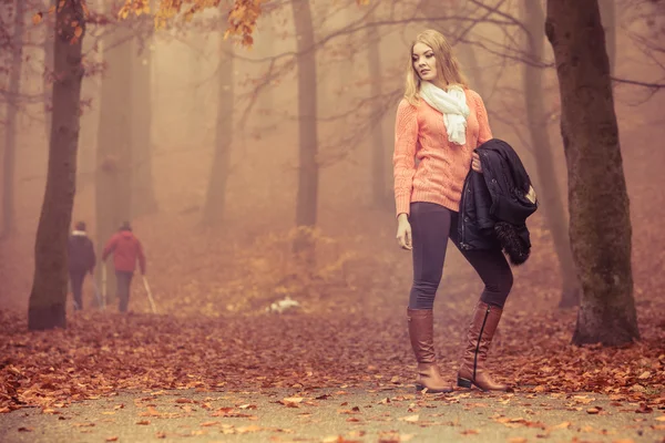 Blondýnka módní bunda v podzimním parku. — Stock fotografie