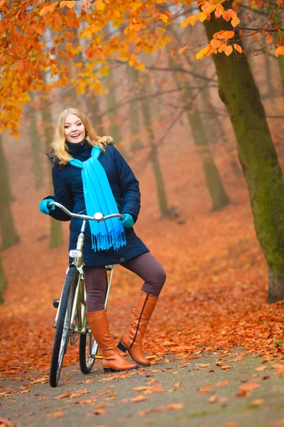 Mujer activa feliz montar en bicicleta en el parque de otoño . —  Fotos de Stock