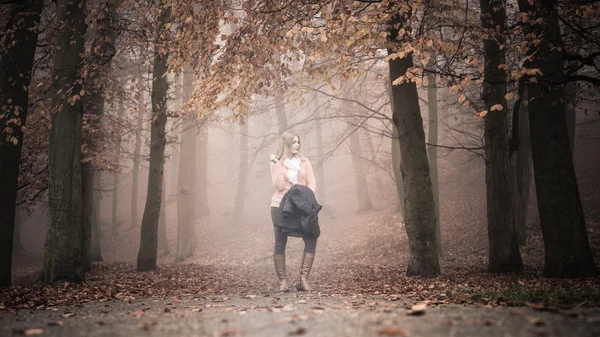 Verloren vrouw mistige herfst park richting zoeken. — Stockfoto