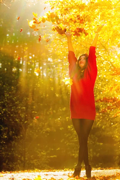 Femme se détendre dans le parc d'automne jetant des feuilles dans l'air — Photo