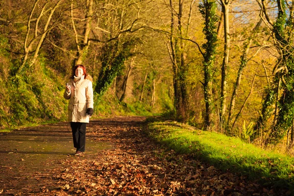 Γυναίκα που περπατά υπαίθρια. πορτοκαλί ηλιόλουστη μέρα πέφτουν τα φύλλα. — Φωτογραφία Αρχείου