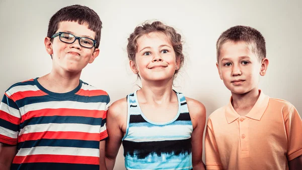 Barn liten flicka och pojkar gör dumma ansiktsuttryck. — Stockfoto