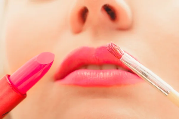 Vrouw die lippenstift met borstel op de lippen aanbrengt. Make-up — Stockfoto