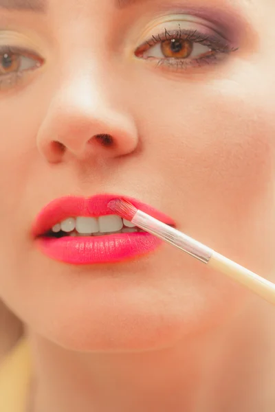 Vrouw die lippenstift met borstel op de lippen aanbrengt. Make-up — Stockfoto