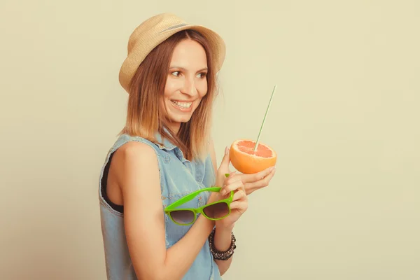 Lycklig kvinna i hatt innehar solglasögon och grapefrukt — Stockfoto