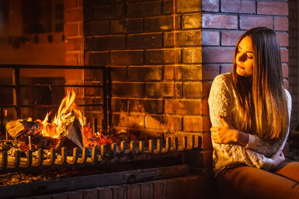 Mujer pensativa relajarse en la chimenea . — Foto de Stock