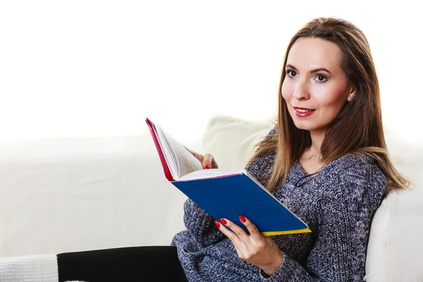 Woman sitting on couch reading — Stock Photo, Image