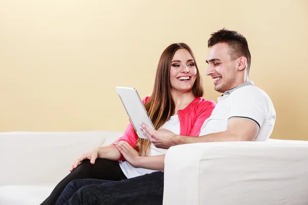 Pár s tablet sedí na gauči doma — Stock fotografie