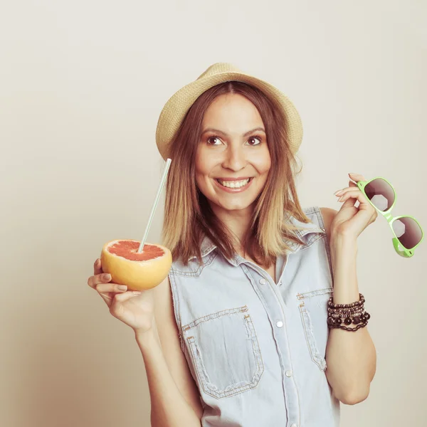 Счастливая женщина в шляпе пьет грейпфрутовый сок. Диета — стоковое фото