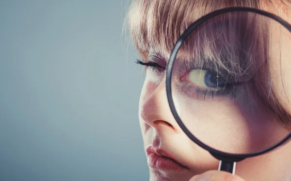 Woman hand holding magnifying glass on eye — Stock Photo, Image