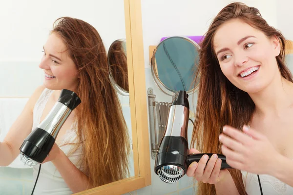 Длинноволосая женщина сушит волосы в ванной комнате — стоковое фото