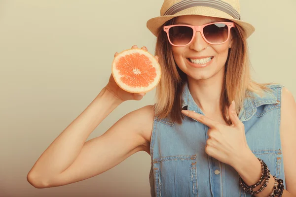 Happy woman pointing at grapefruit — Stockfoto