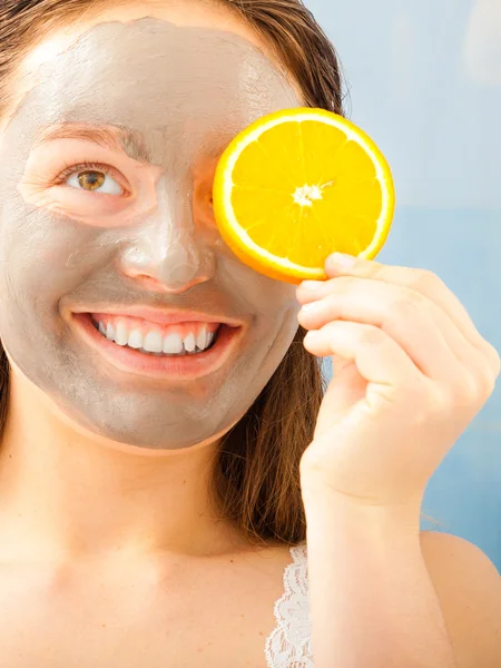 Mulher com máscara facial segurando laranja — Fotografia de Stock