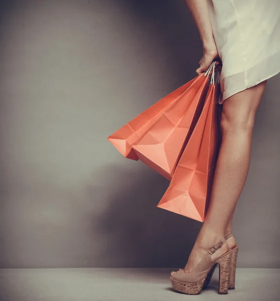 Femme tenant des sacs à provisions en papier rouge — Photo