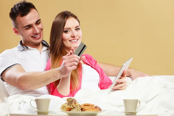 Young couple with tablet and credit card at home — Stock Photo, Image