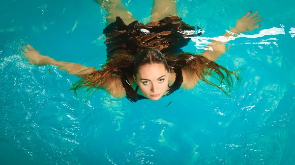Frau schwimmt entspannt im Schwimmbadwasser. — Stockfoto