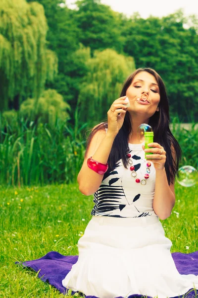 Kvinna tjej blåser såpbubblor utomhus. — Stockfoto