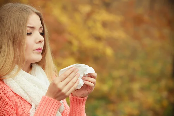 Donna malata nel parco autunnale starnutisce nel tessuto . — Foto Stock