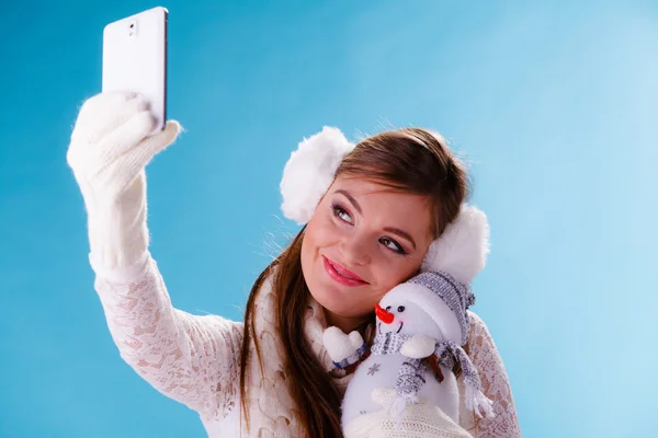 Frau mit kleinem Schneemann macht Selfie-Foto. — Stockfoto