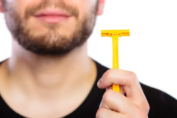 Young man with beard showing razor blade — Stock Photo, Image