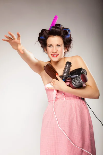 Funny girl styling hair holds many accessories — Stock Photo, Image