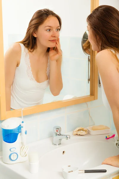 Woman  looking in mirror.