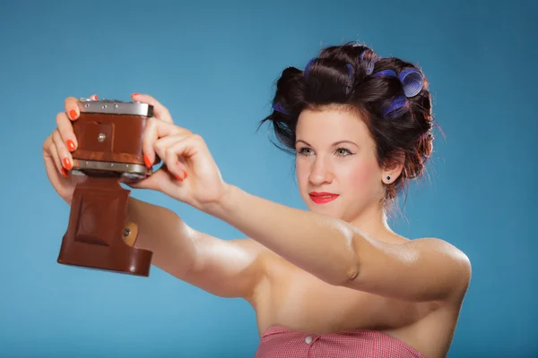 Girl in hair curlers taking picture with old camera — Stock Photo, Image