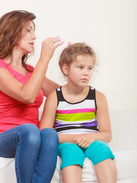 Madre pettinando i capelli per figlia — Foto Stock