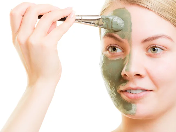 Vrouw aanbrengen met borstel klei modder masker haar gezicht — Stockfoto