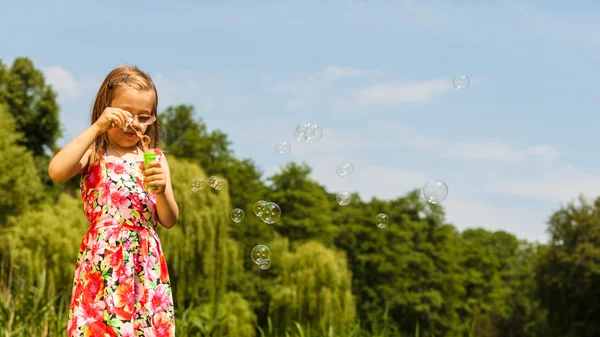 Little girl child blowing soap bubbles outdoor. — Stock Photo, Image