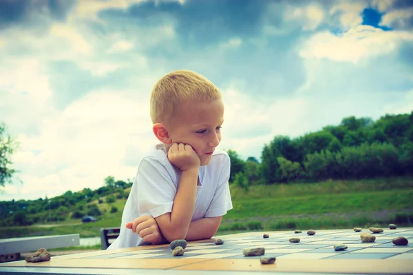 Little boy clever child playing checkers in park — Stock Photo, Image