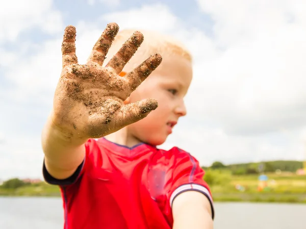 Child playing outdoor showing dirty muddy hands. — Stock Photo, Image