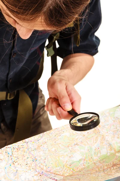 Man tourist reading map with magnifying glass — Stock Photo, Image