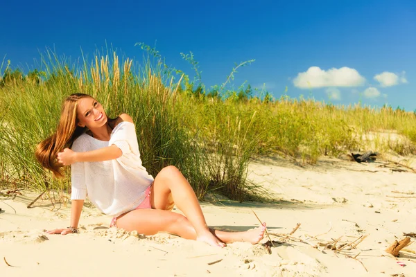 Junge Frau posiert in grasbewachsener Düne — Stockfoto