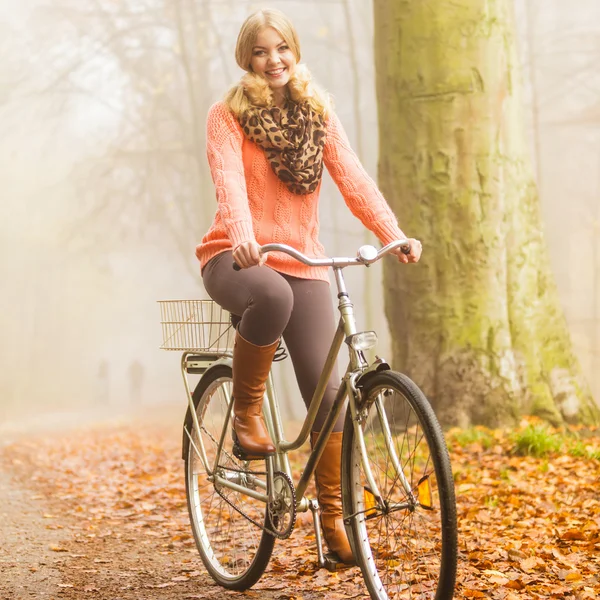 Kobieta jazdy konnej rower w parku jesień. — Zdjęcie stockowe