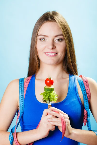 Flicka anläggning gaffel med grönsaker — Stockfoto