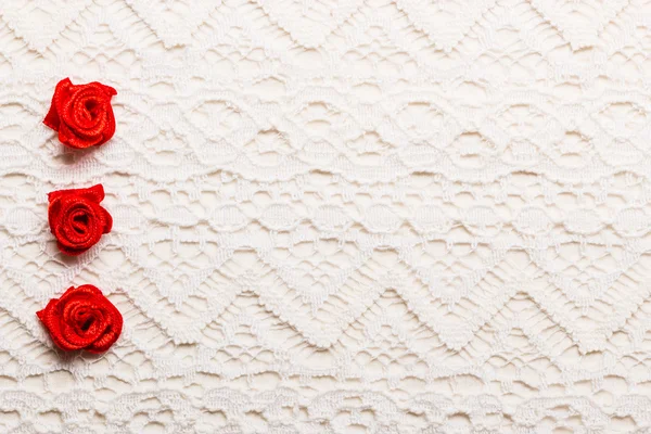 Рамка из красных шелковых роз на кружеве — стоковое фото