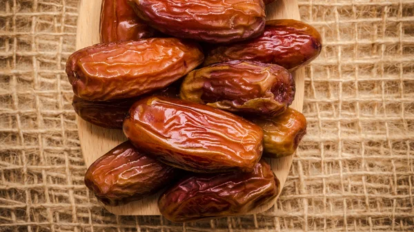 Dried dates on wooden spoon cloth background — Stock Photo, Image