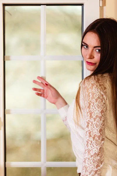 Beautiful woman looking through window. — Stock Photo, Image