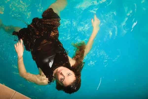 Женщина плавает расслабляясь в бассейне воды . — стоковое фото